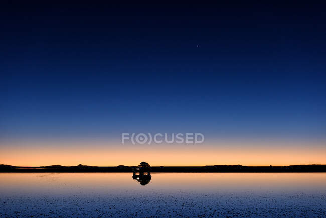 Silhouette di un'auto all'alba sul piatto di sale Uyuni, Altiplano, Bolivia — Foto stock
