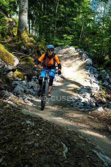Mujer montando una bicicleta de montaña a lo largo de un camino de flujo en un parque de bicicletas, Glarus, Suiza - foto de stock