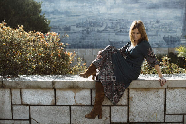Портрет женщины, сидящей на стене, Лиссабон, Португалия — стоковое фото