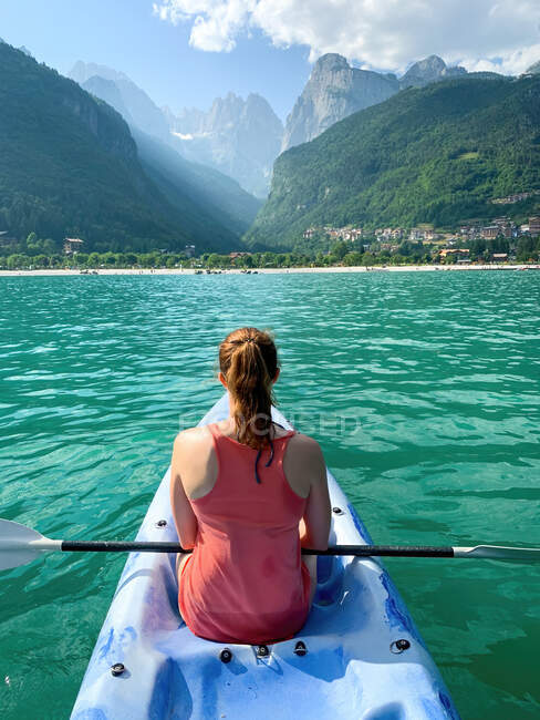 Visão traseira de uma jovem mulher de caiaque, lago Molveno, Trentino, Itália — Fotografia de Stock