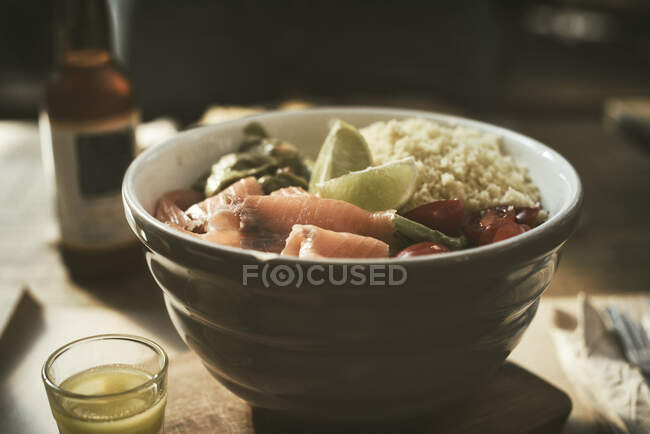 Schüssel Lachs, Tomaten und Cous-Cous-Salat mit einem Glas Bier — Stockfoto
