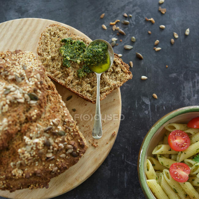 Pasta with cherry tomatoes and parsley with brown bread and pesto — Stock Photo
