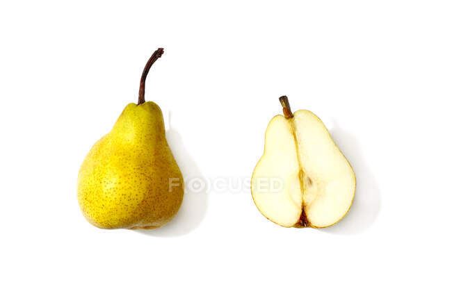 Whole pear next to a halved pear — Stock Photo