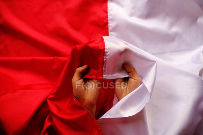 Mãos segurando uma bandeira indonésia, Indonésia — Fotografia de Stock
