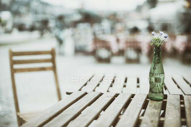 Квітки в пляшці на столі кафе (Порто, Португалія). — стокове фото