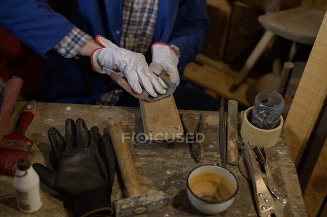 Tischler schleift eine Holzplanke — Stockfoto