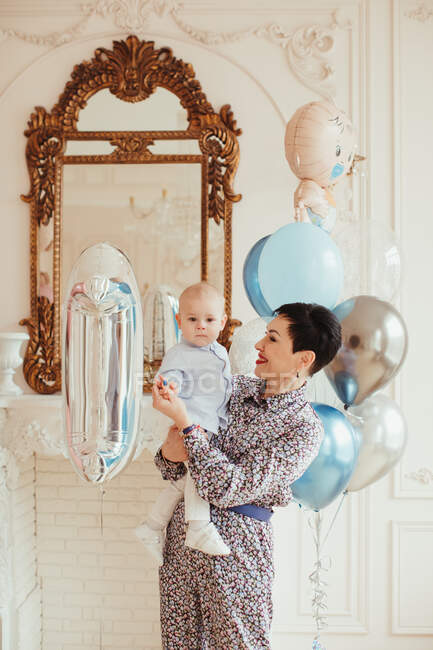 Portrait of a smiling woman holding her grandson on his 1st birthday — Stock Photo
