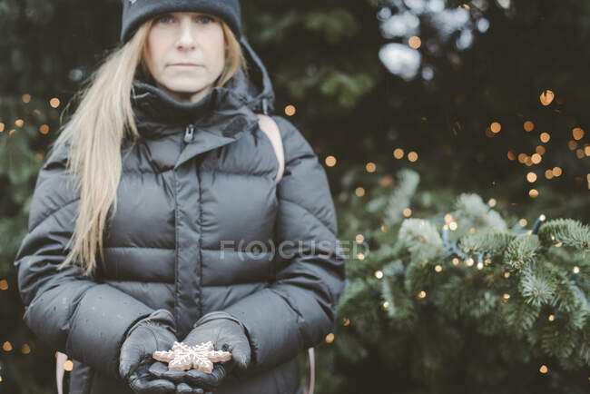 Donna con una stella a forma di biscotto di Natale — Foto stock