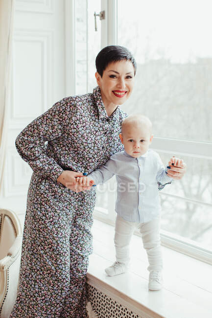 Portrait of a grandmother helping her grandson stand up — Stock Photo