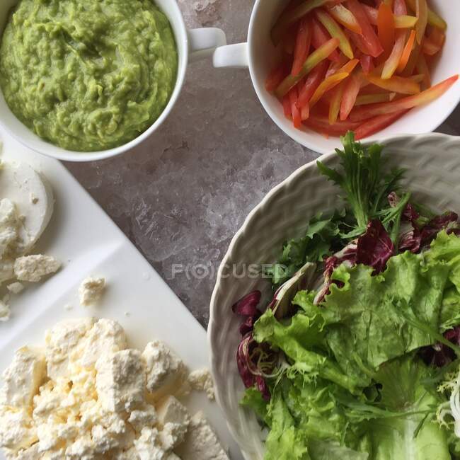 Салат, сыр фета, гуакамоле и помидоры на льду — стоковое фото