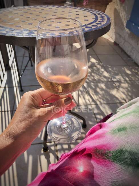 Donna che tiene un bicchiere di vino rosato — Foto stock