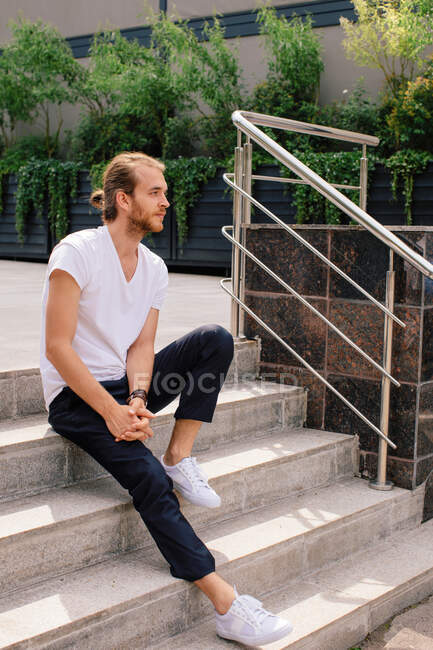 Hombre sentado en escalones al aire libre, Rusia - foto de stock