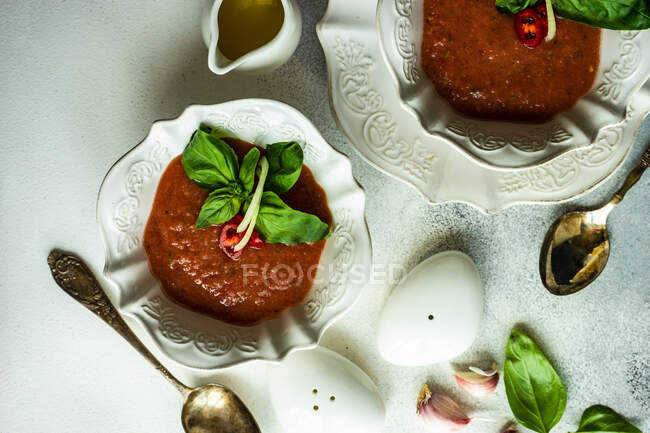 Two bowls of gazpacho soup with salt and pepper pots — Stock Photo