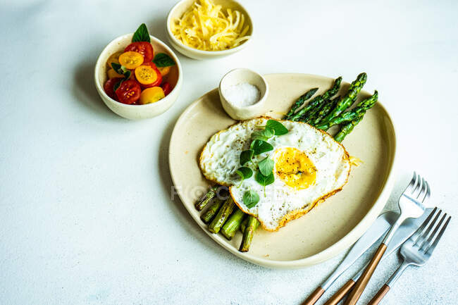 Ovos fritos com ovo e legumes em prato branco — Fotografia de Stock