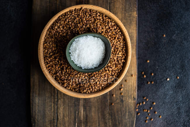Bowl of salt on top of a bowl of buckwheat — Stock Photo