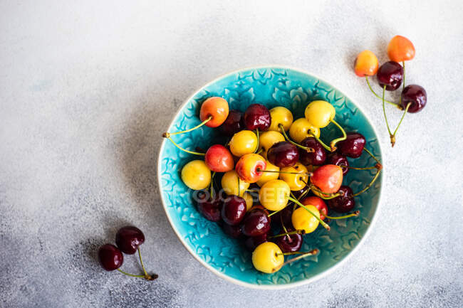 Bowl of multi coloured cherries — Stock Photo