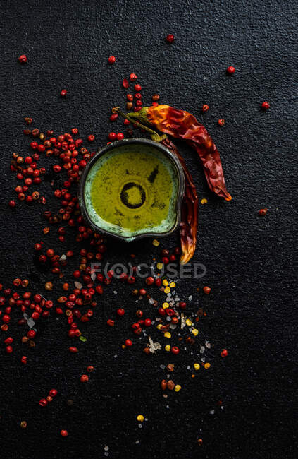 Huile, piment et poivrons mélangés sur une table — Photo de stock