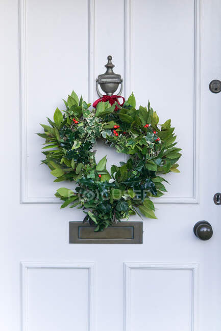 Corona de Navidad colgando en una puerta principal, Inglaterra, Reino Unido - foto de stock