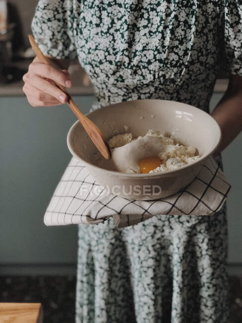 Жінка стоїть на кухні робить чізкейк — стокове фото
