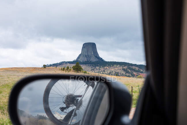 Pneumatico per bicicletta e riflessione del paesaggio in uno specchio alare per auto, Devil's Tower, Wyoming, Stati Uniti — Foto stock