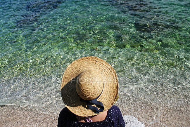 Vista aérea de una mujer sentada en la playa, Krk, Croacia - foto de stock