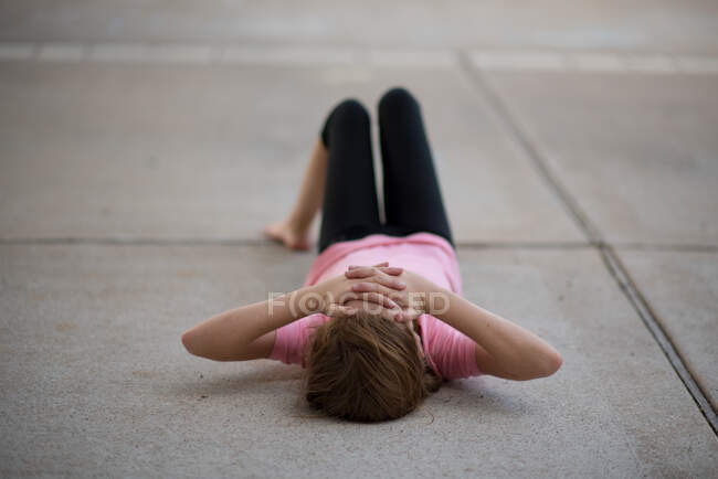 Розчарована дівчина лежить на дорозі, закриваючи обличчя руками, США. — стокове фото