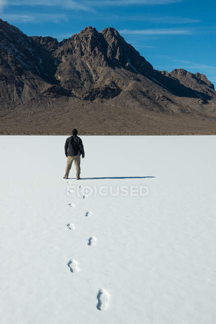 Man walking in the snow on the Racetrack Playa, Death Valley National Park, California, USA — Stock Photo