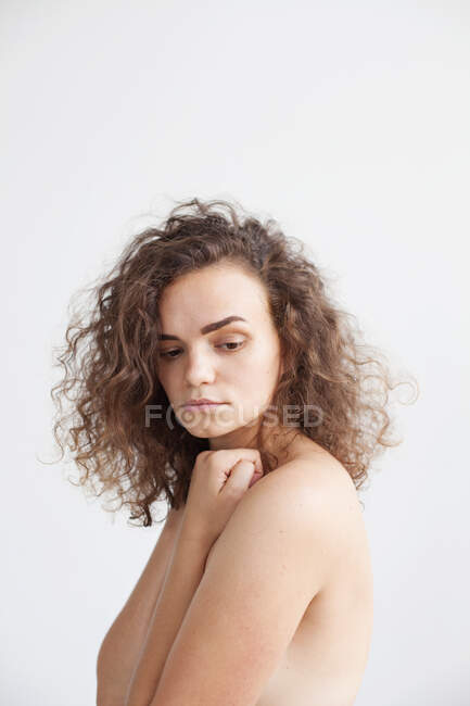 Portrait of a naked woman with her hands covering her breasts — Stock Photo
