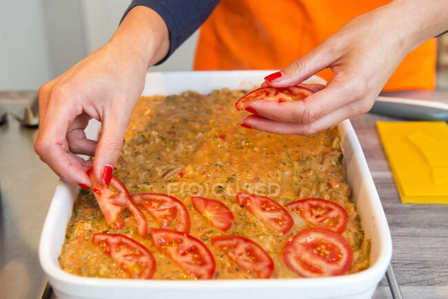 Gros plan d'une femme préparant un plat de lasagne — Photo de stock