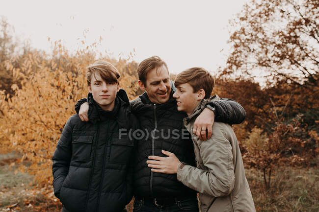 Retrato de un padre con sus dos hijos en el paisaje rural, Países Bajos - foto de stock