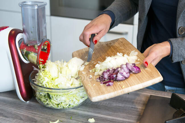 Woman chopping vegetables in a kitchen — Stock Photo