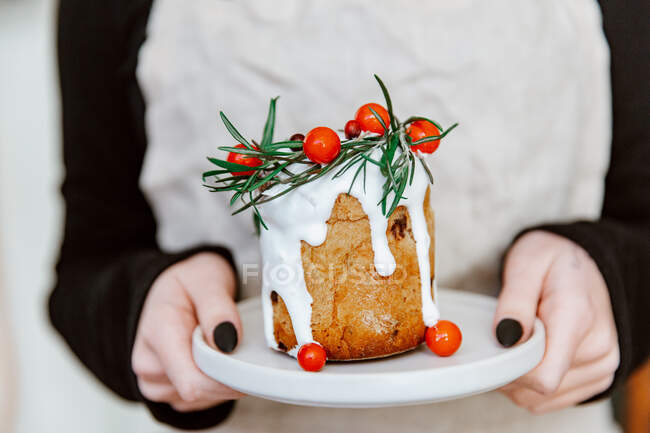Primo piano di un piatto di mani femminili con un pane bianco su uno sfondo di legno. il concetto di — Foto stock