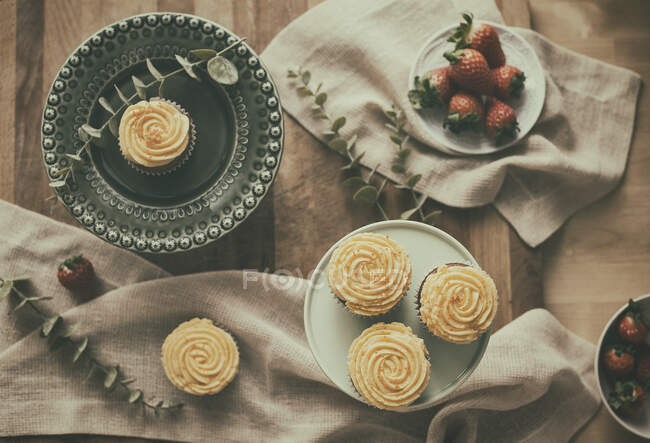Cupcakes and strawberries on a table — Stock Photo