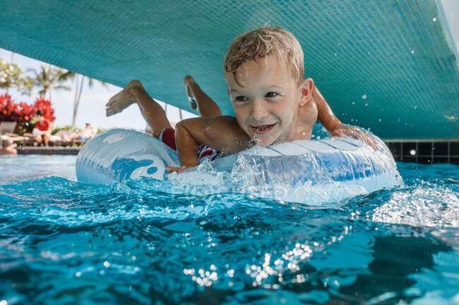 Boy lying on an inflatable rubber ring, Hawaii, USA — Stock Photo