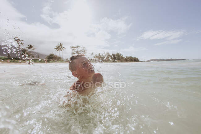 Teenage boy playing in ocean, Hawaii, USA — Stock Photo
