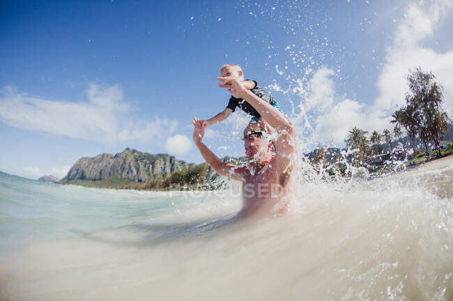 Father and son playing in the ocean, Hawaii, USA — Stock Photo