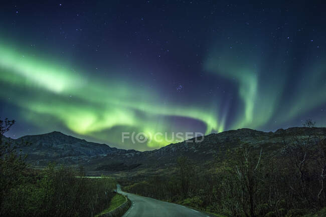 Northern lights over mountain road, Flakstad, Lofoten, Nordland, Norway — Stock Photo