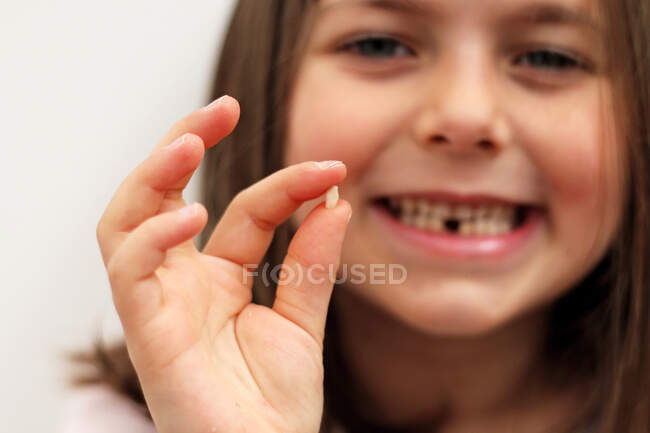 Ritratto di una ragazza dentata con il suo primo dente da latte caduto — Foto stock