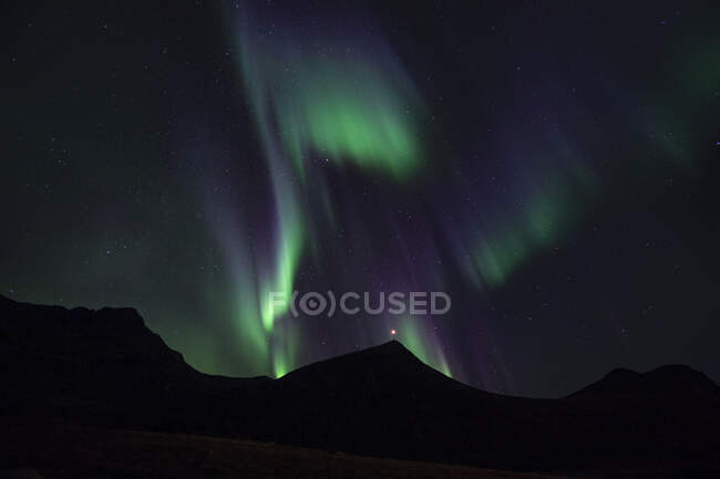 Luces boreales sobre Mt Montinden, Flakstad, Lofoten, Nordland, Noruega - foto de stock