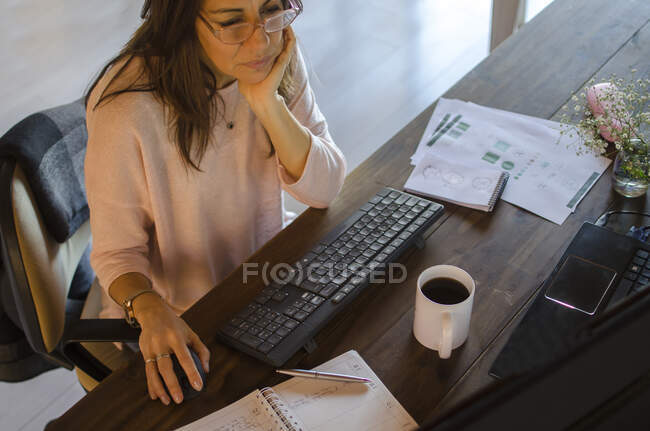 Mulher sentada em sua mesa de trabalho — Fotografia de Stock