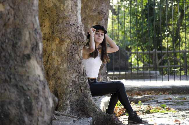 Девочка-подросток сидит на бордюре между деревьями, Аргентина — стоковое фото