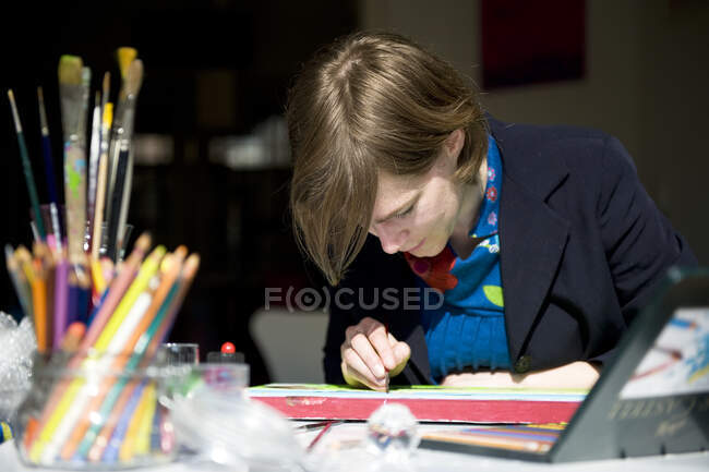 Porträt einer Künstlerin beim Malen eines Bildes in ihrem Atelier — Stockfoto
