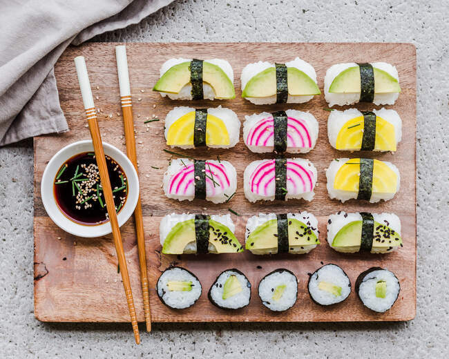 Sushi vegano con palillos y salsa de soja - foto de stock