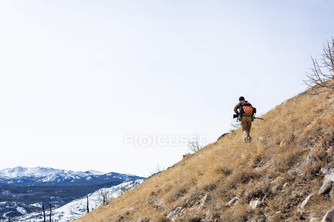 Man hiking in mountains hunting for birds, USA — Stock Photo