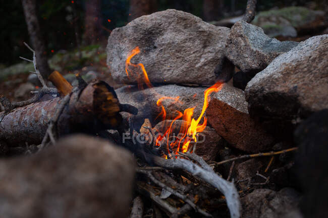 Open camp fire surrounded by rocks, USA — Stock Photo