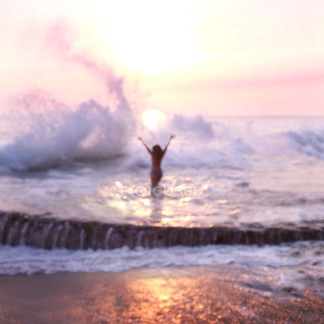 Mulher de pé em uma piscina ao pôr do sol, Laguna Beach, Califórnia, EUA — Fotografia de Stock