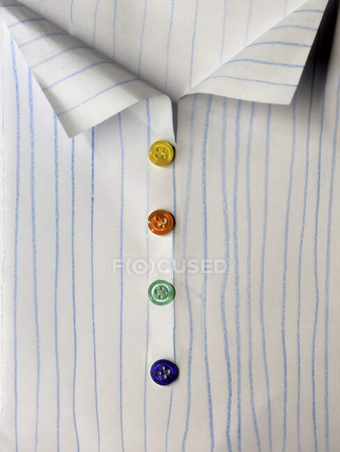 Primer plano de una camisa conceptual con botones multicolores - foto de stock
