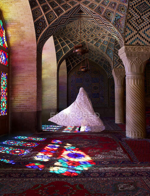Mujer vestida con vestido tradicional iraní caminando por la Mezquita Rosa, Shiraz, Irán - foto de stock