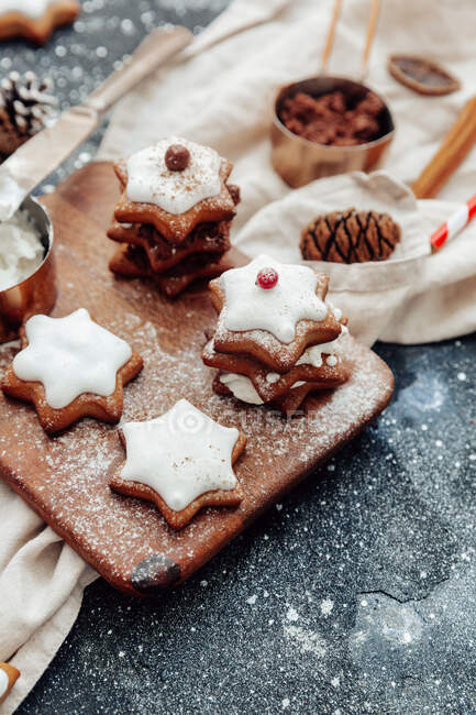 Galletas de jengibre de Navidad con azúcar glaseado y canela sobre un fondo de madera. - foto de stock