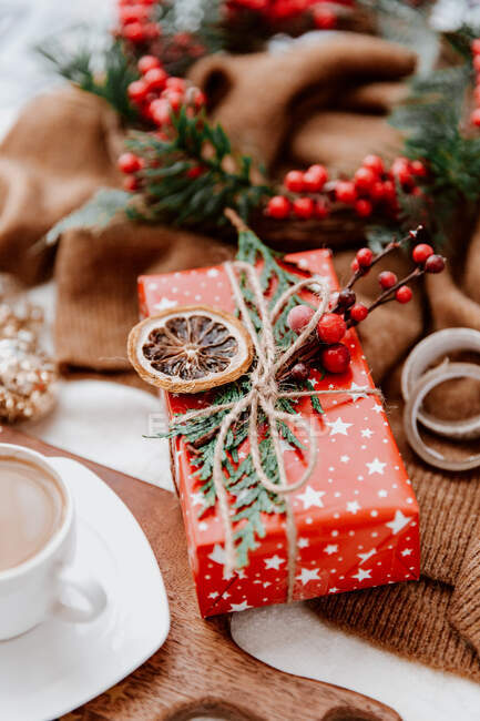 Cup of coffee next to a wrapped Christmas gift — Stock Photo